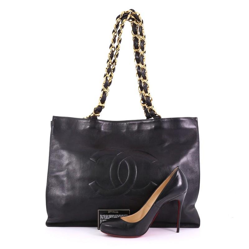 This Chanel Vintage CC Chain Tote Lambskin XL, crafted in black lambskin leather, features dual woven in leather chain link straps and gold-tone hardware. It opens to a black leather interior with zip pocket. Hologram sticker reads: 3218658. **Note:
