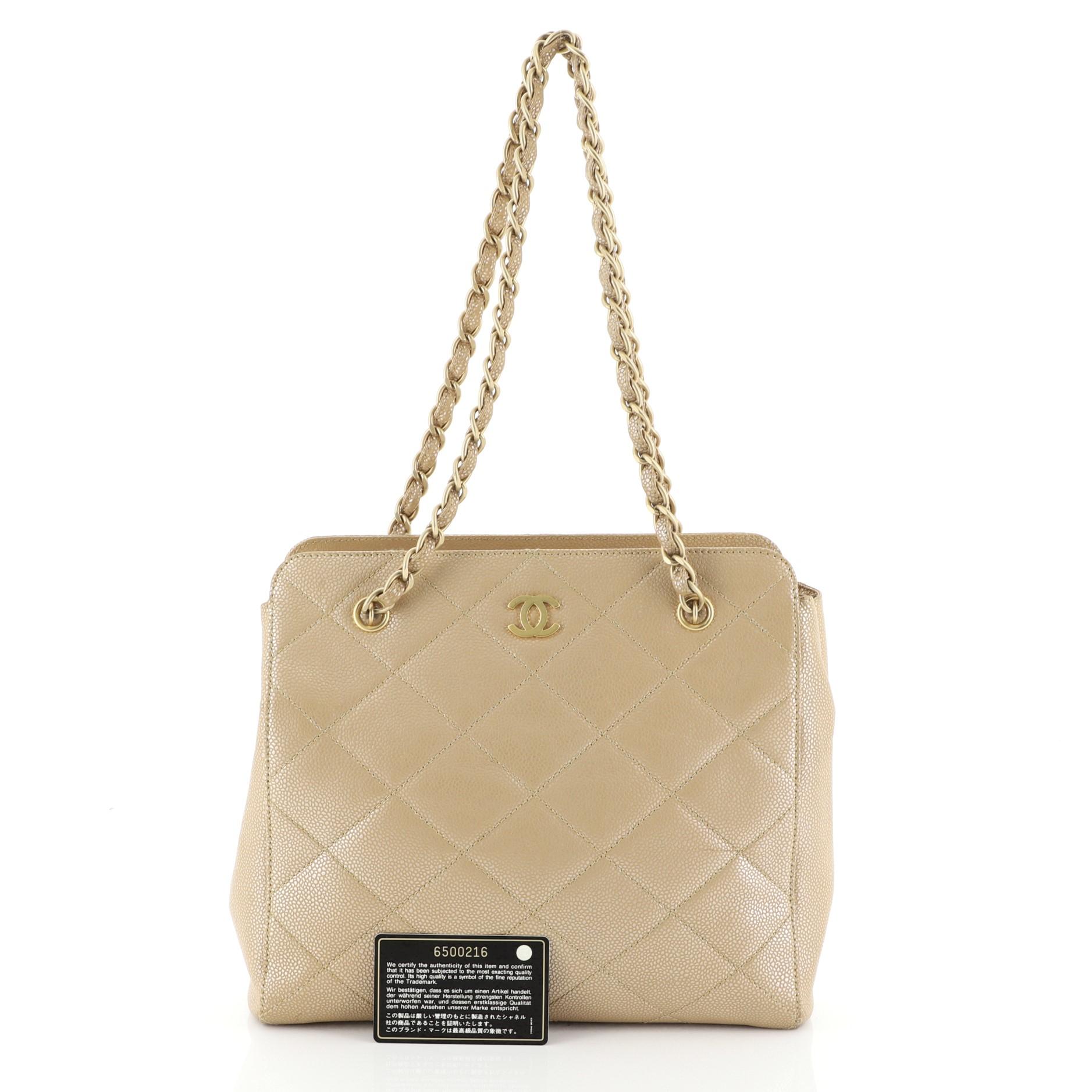 This Chanel Vintage CC Chain Tote Quilted Iridescent Caviar Medium, crafted from neutral quilted iridescent caviar leather, features woven-in leather chain straps and matte gold-tone hardware. It opens to a neutral leather interior with zip pocket.