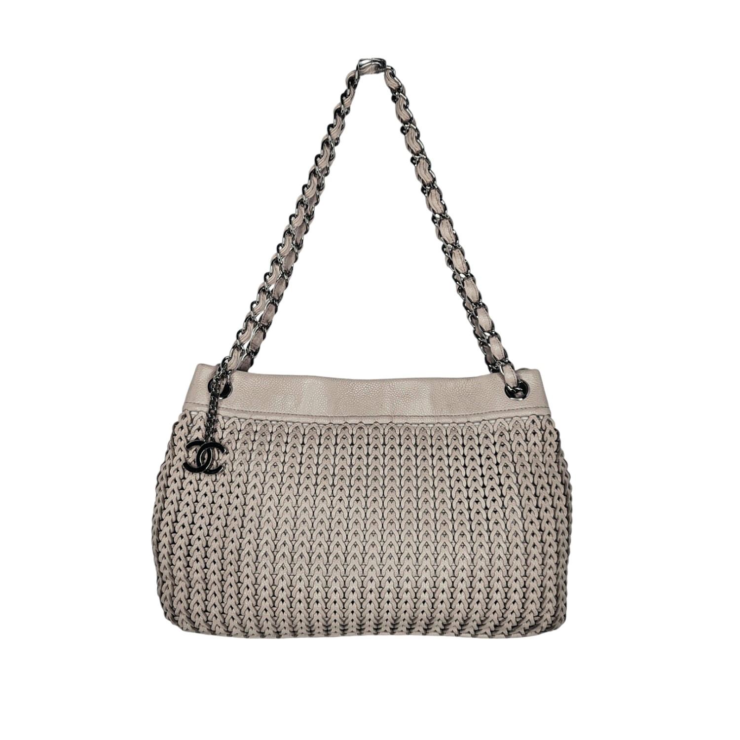Complete your outfit with this timeless Chanel Vintage CC Charm Tote. Crafted from luxurious lambskin leather in a soft beige hue, this woven masterpiece exudes both elegance and casual sophistication. Includes an Entrupy Certificate of Authenticity