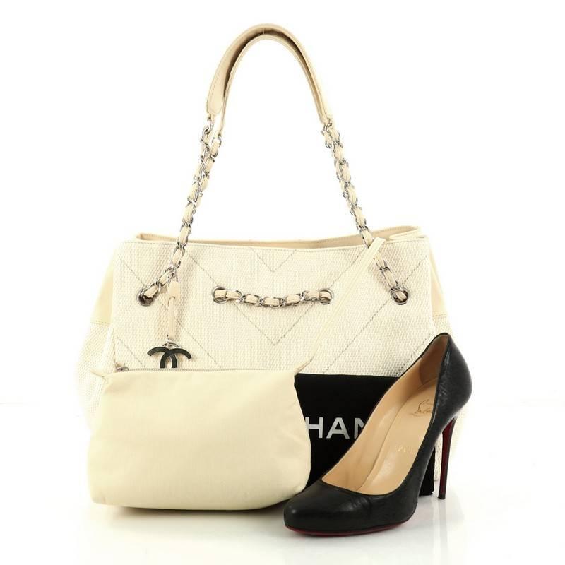 This authentic Chanel Vintage CC Charm Tote Chevron Canvas Large showcases an elegant and timeless design made for Chanel lovers. Crafted in off white chevron canvas, this tote features woven-in leather chain straps, oversized CC gold charm,