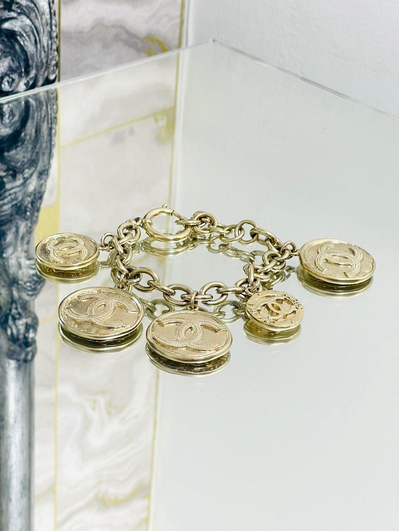 Chanel Vintage 'CC' Logo Coin Bracelet

Bracelet à gros maillons en or avec cinq pièces de monnaie en médaillon de tailles différentes sur la face latérale.  ayant le  CC