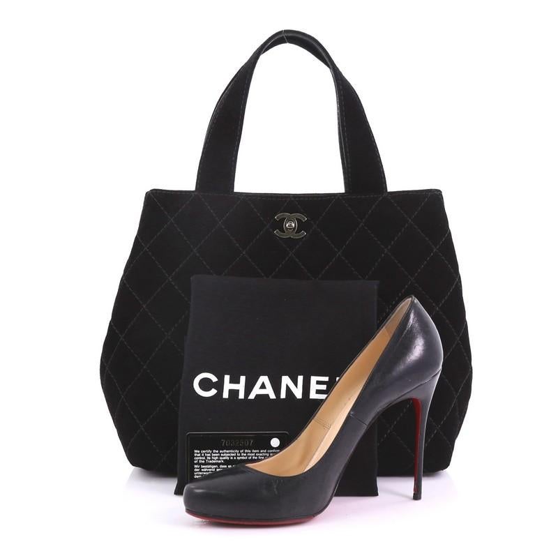 This Chanel Vintage CC Tote Quilted Suede Small, crafted in black quilted suede, features dual-flat suede handles, CC turn-lock, and aged silver-tone hardware. Its turn-lock cloaure opens to a black fabric interior with slip pockets. Hologram