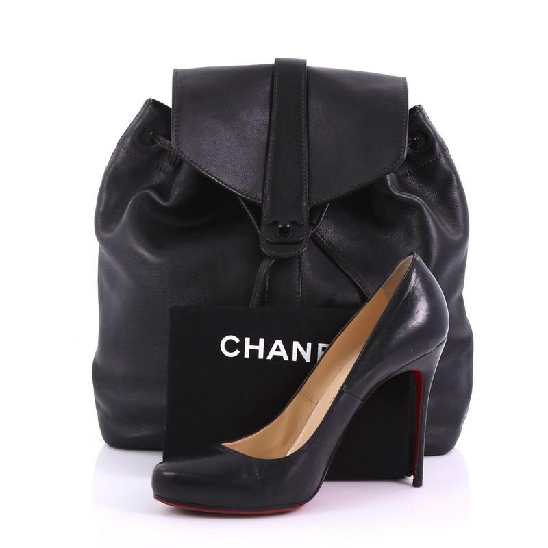 This Chanel Vintage CC Turn Lock Backpack Leather Medium, crafted in black leather, features flat backpack straps and black-tone hardware. Its CC turn-lock and drawstring closures open to a black fabric interior with zip pockets. Hologram sticker