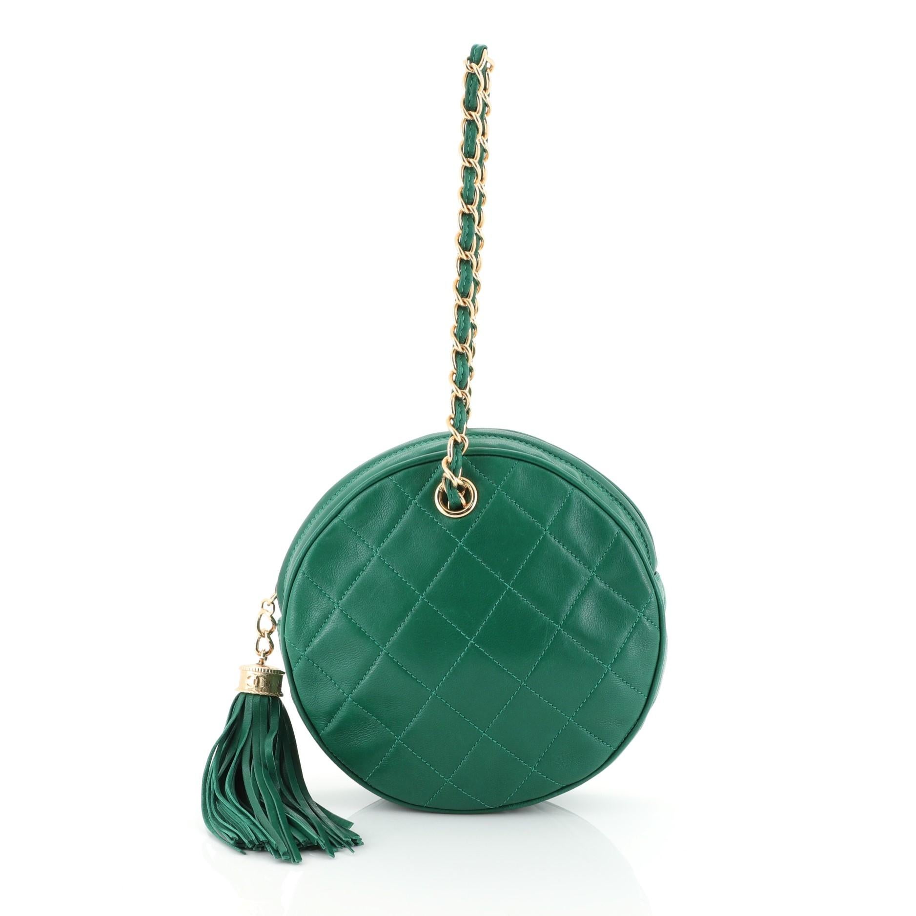 This Chanel Vintage Chain Round Clutch Quilted Lambskin Small, crafted from green quilted lambskin leather, features woven-in leather chain handle, fringe tassel, and gold-tone hardware. Its zip closure opens to a neutral leather interior. Hologram