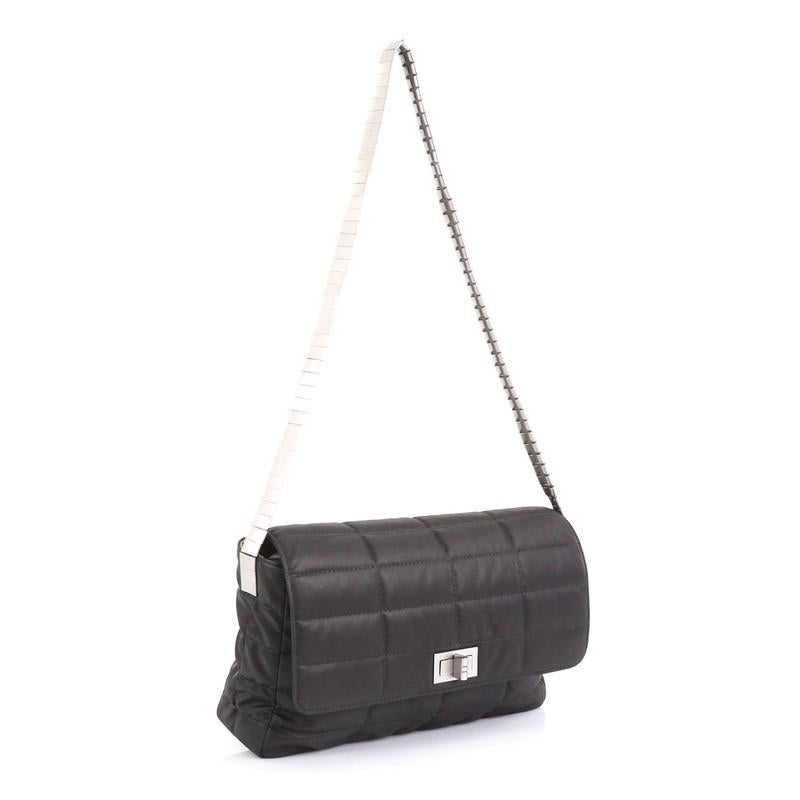 This Chanel Vintage Chocolate Bar Mademoiselle Flap Bag Quilted Nylon Medium, crafted from gray quilted leather, features chain-link strap and matte silver-tone hardware. Its mademoiselle turn-lock closure opens to a neutral fabric interior with