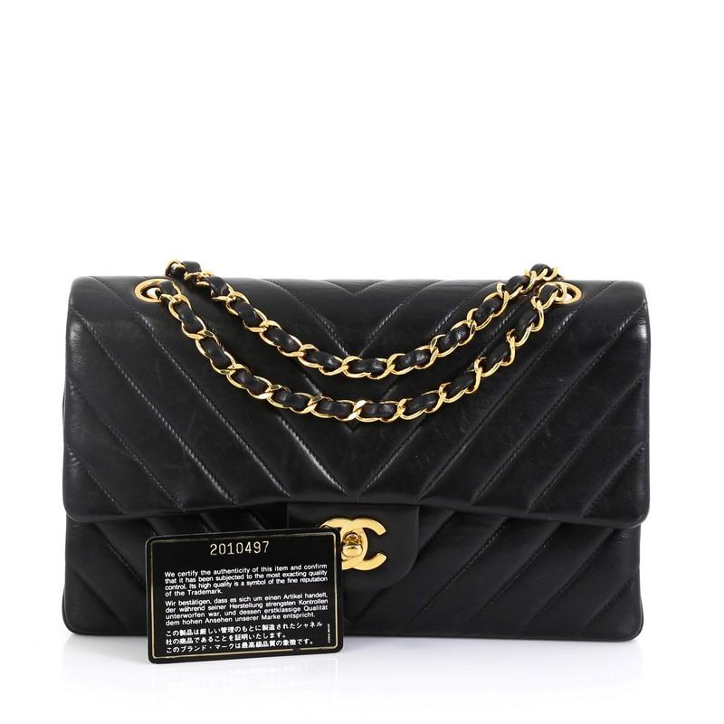 This Chanel Vintage Classic Double Flap Bag Chevron Lambskin Medium, crafted from black chevron lambskin leather, features woven-in leather chain strap, exterior back pocket and gold-tone hardware. Its double flap and CC turn-lock closure opens to a