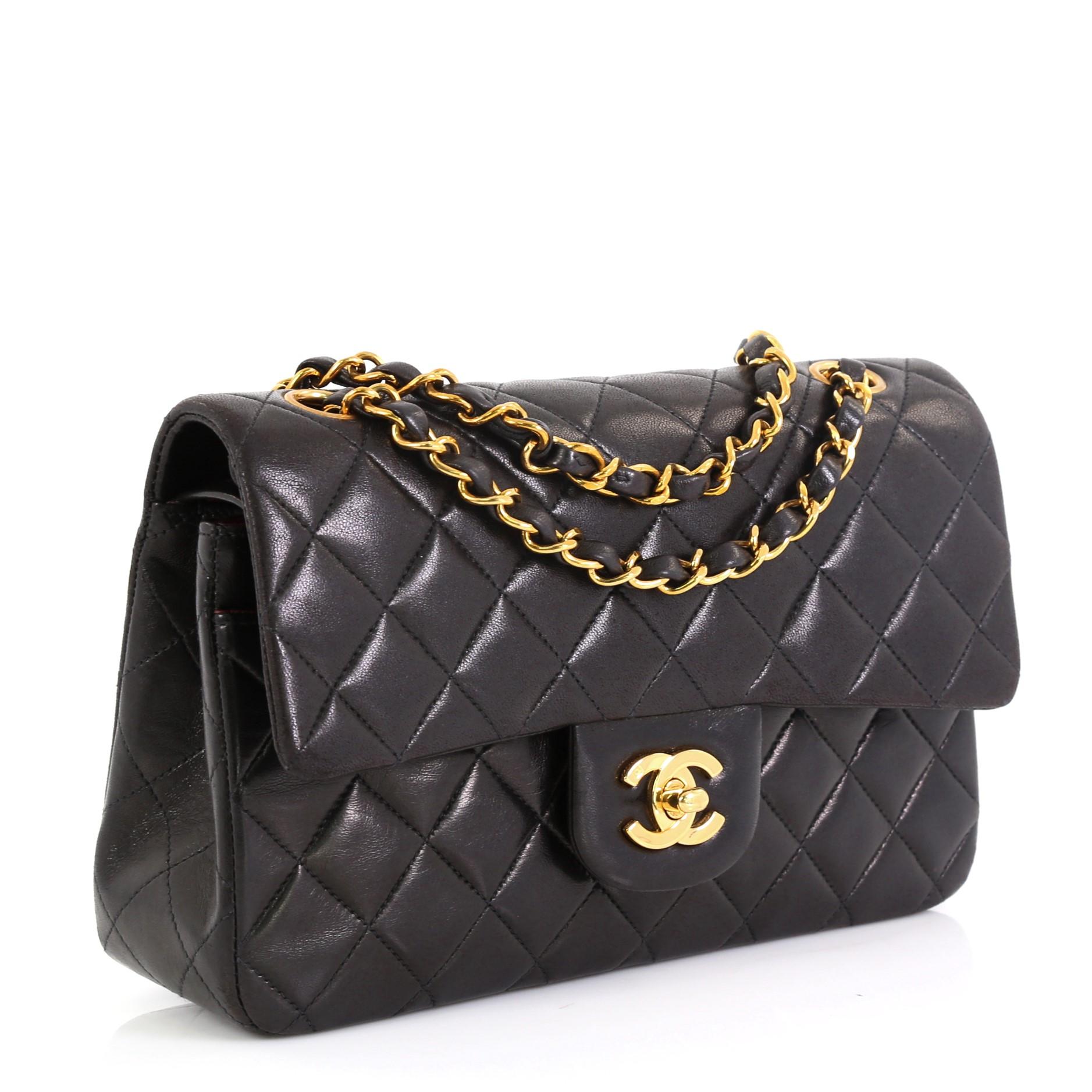 This Chanel Vintage Classic Double Flap Bag Quilted Lambskin Small, crafted from black quilted lambskin leather, features woven-in leather chain strap, exterior back slip pocket and gold-tone hardware. Its double flap and frontal CC turn-lock