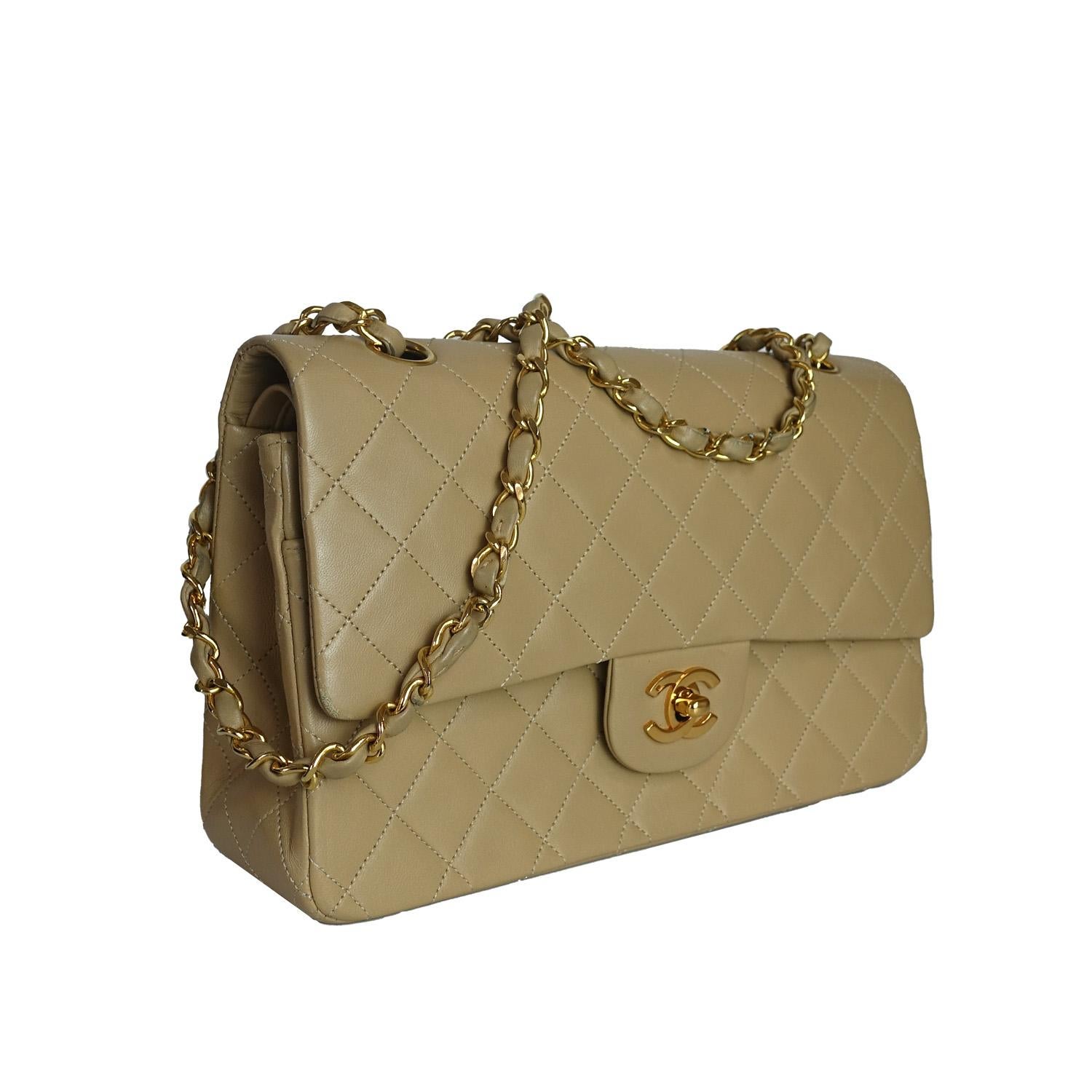 A timeless icon from Chanel’s early 90s era, this Chanel Vintage Classic Flap Medium Bag is crafted in buttery beige lambskin with signature diamond quilting and luxurious gold-toned hardware. Featuring the iconic CC turn-lock closure, the flap