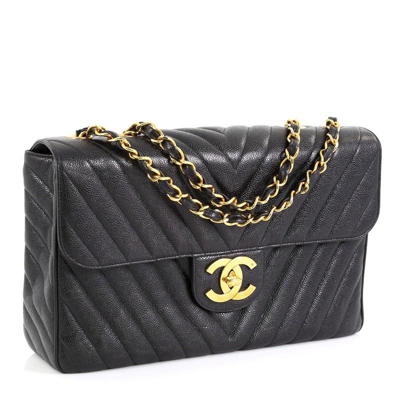 This Chanel Vintage Classic Single Flap Bag Chevron Caviar Maxi, crafted in black chevron caviar leather, features woven-in leather chain link straps, exterior back slip pocket, and gold-tone hardware. Its CC turn-lock closure opens to a black