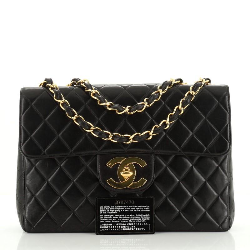 This Chanel Vintage Classic Single Flap Bag Quilted Lambskin Jumbo, crafted in black quilted lambskin, features woven-in leather chain link strap, exterior back slip pocket, and gold-tone hardware. Its CC turn-lock closure opens to a black leather