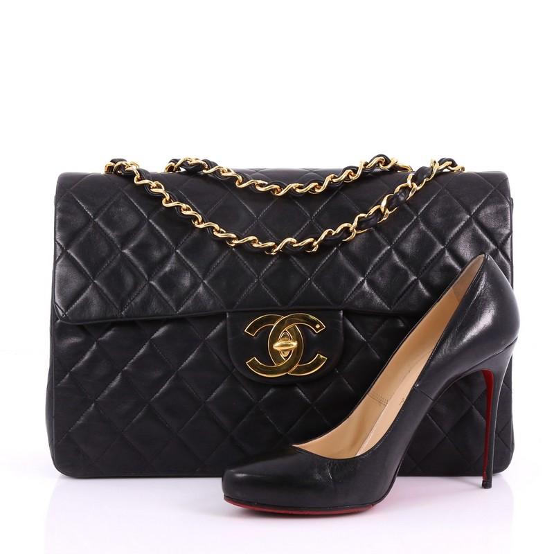 This Chanel Vintage Classic Single Flap Bag Quilted Lambskin Maxi, crafted in black quilted lambskin leather, features woven-in leather chain strap, exterior back pocket, and gold-tone hardware. Its turn-lock closure opens to a burgundy leather