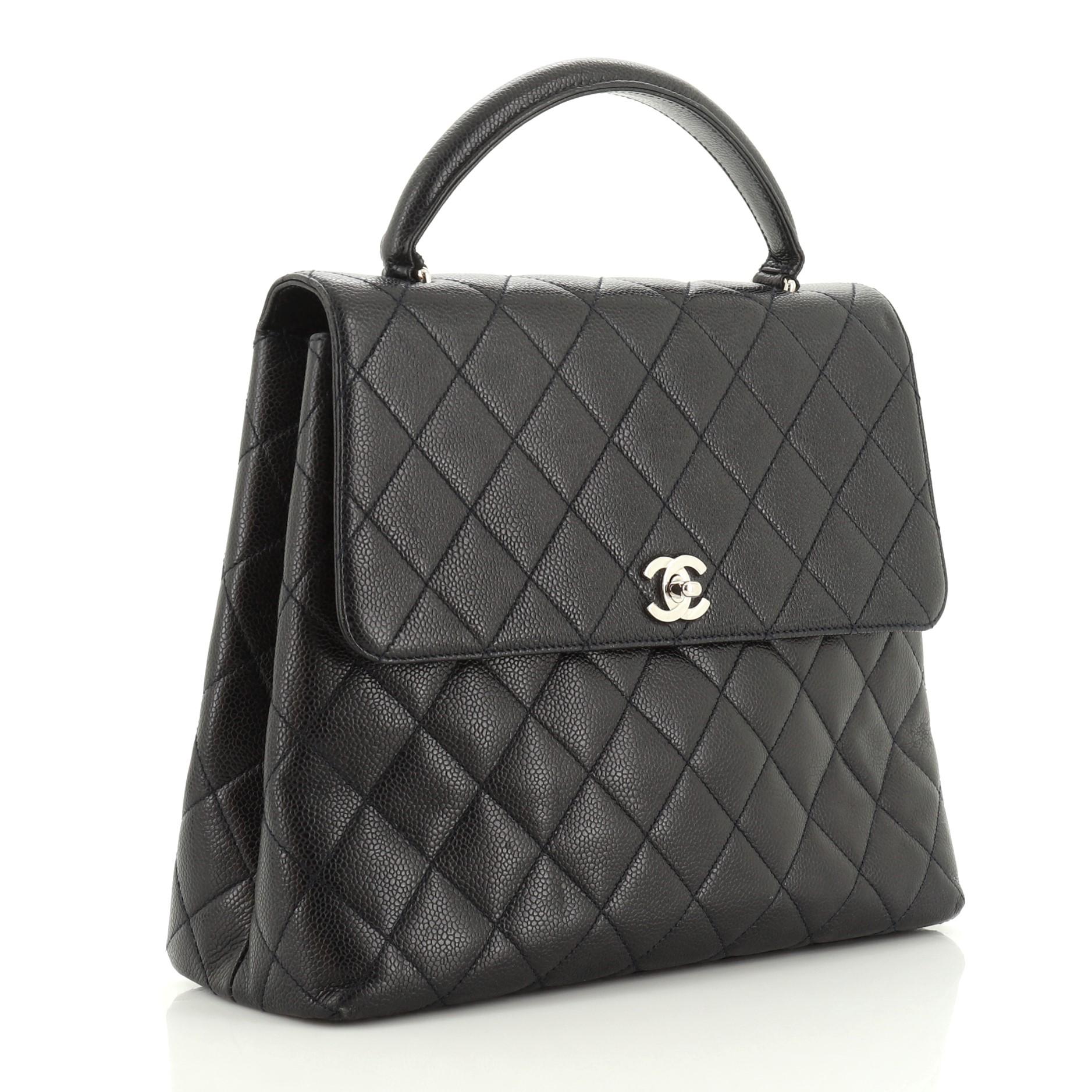 This Chanel Vintage Classic Top Handle Flap Bag Quilted Caviar Jumbo, crafted in blue quilted caviar leather, features a single looped top handle, exterior slip pocket, and silver-tone hardware. Its signature CC turn-lock closure opens to a blue