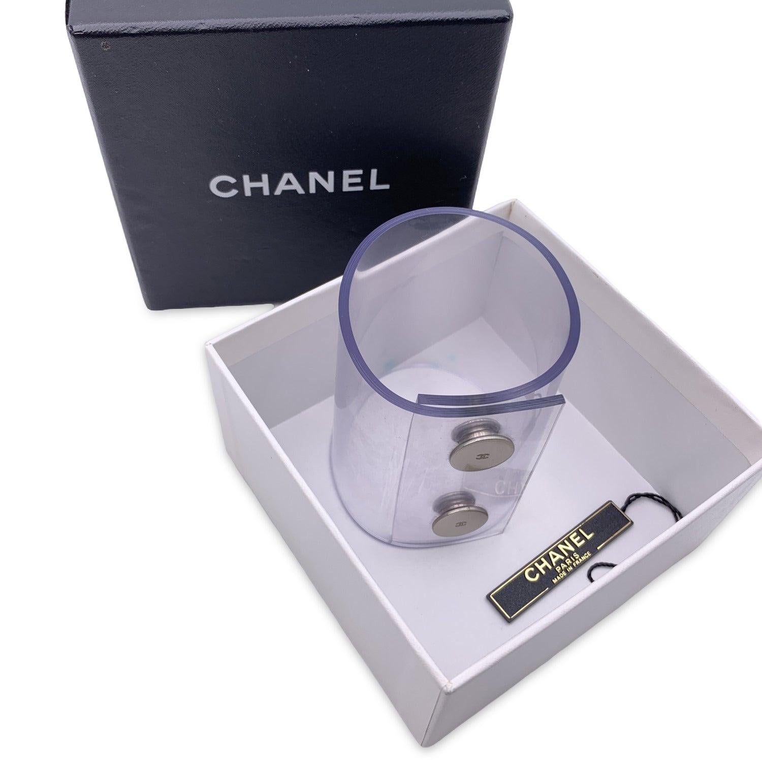 Lovely wide bracelet by CHANEL. Oversized soft plastic band with two snap buttons closing. CC - Chanel logo engraved on the buttons. Stamped 'Chanel - 00 CC C - Made in France' . Height: 2.75 inches - 7 cm. Will fit up to approx. 6.75 inches - 17. 2