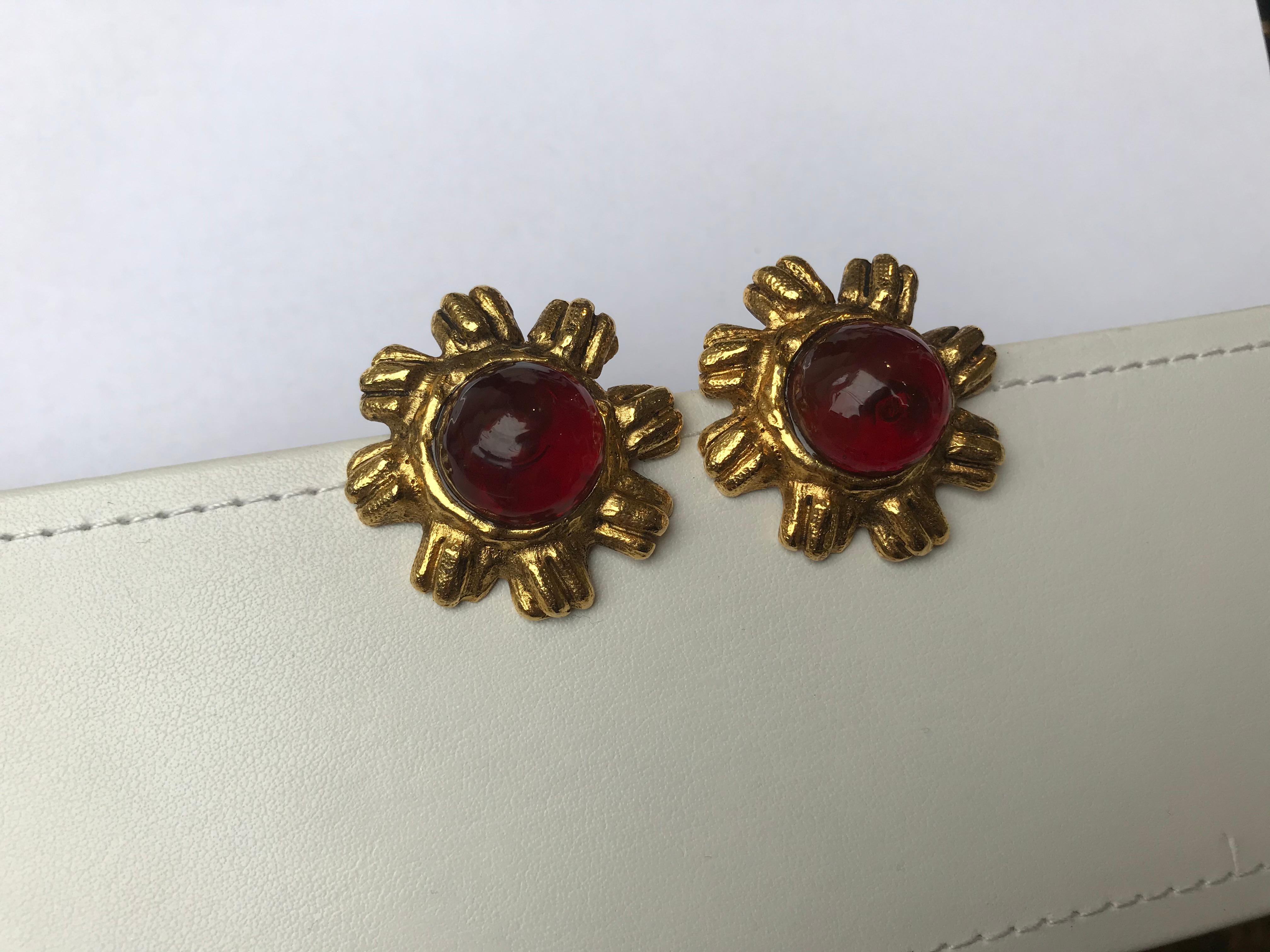 Gold-tone metal. Red gemstone at center. Clip-on closures.