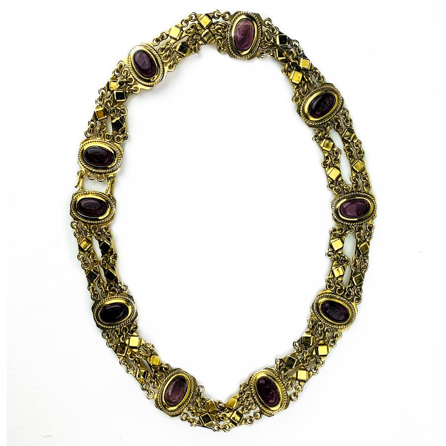 The belt is signed CHANEL. It represents a long frieze composed of a double chain in golden metal, on which are placed oval segments in amethyst glass paste. It dates from the 70s.
The belt is in very good condition for a vintage. It is 77