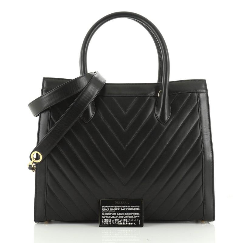 This Chanel Vintage Convertible Tote Chevron Lambskin Large, crafted in black chevron lambskin leather, features dual rolled handles and gold-tone hardware. It opens to a black leather interior. Hologram sticker reads: 2865556. 

Condition: Great.