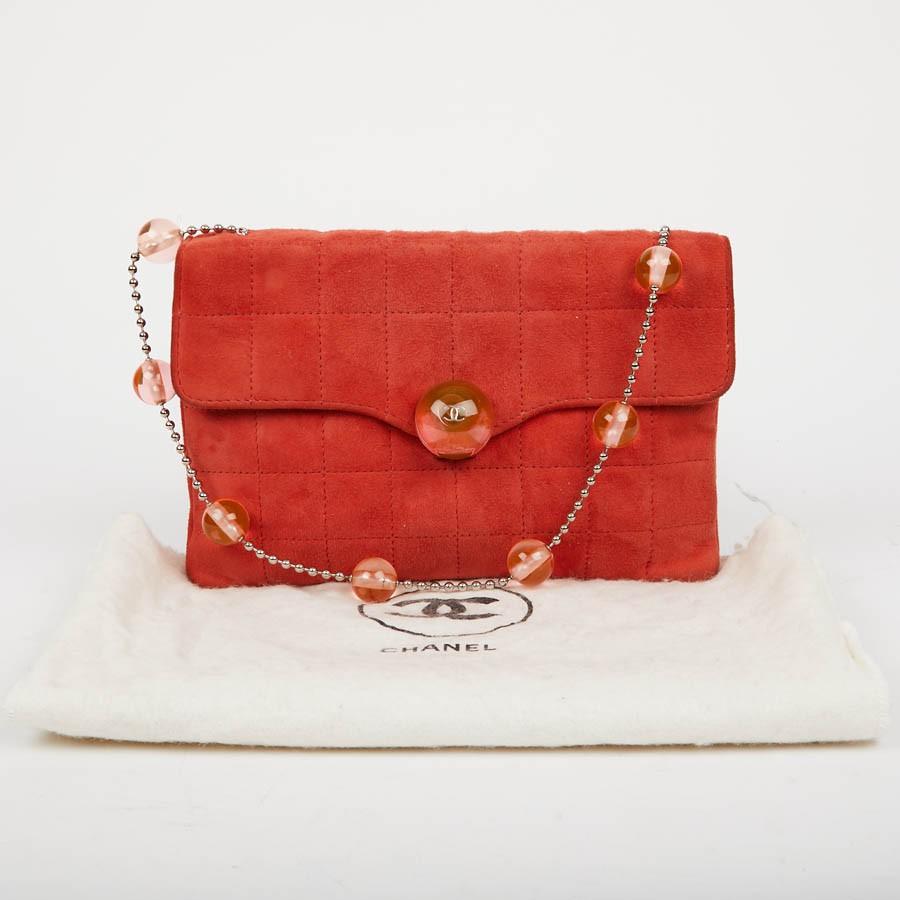 CHANEL vintage coral suede bag.
It has two storage gussets with a fabric lining with a small zipped pocket. The corners are slightly blackened. Closure with a toggle clasp.
It is worn on the shoulder with its small chain (44cm).
In very good