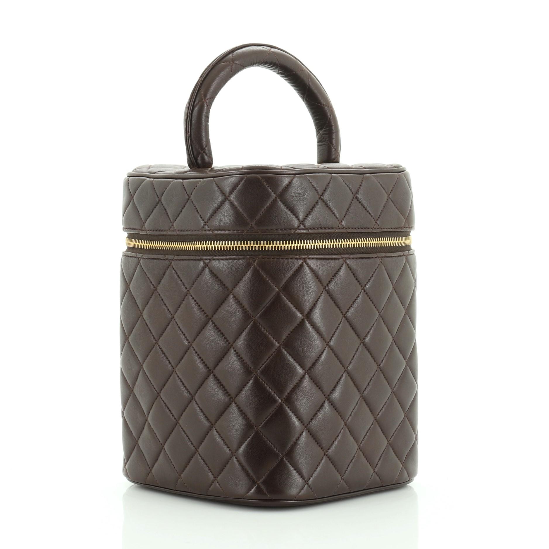 This Chanel Vintage Cosmetic Case Quilted Lambskin Tall, crafted in brown lambskin leather, features a leather top handle, and gold-tone hardware. Its zip-around closure opens to a brown leather interior with slip pocket. Hologram sticker reads: