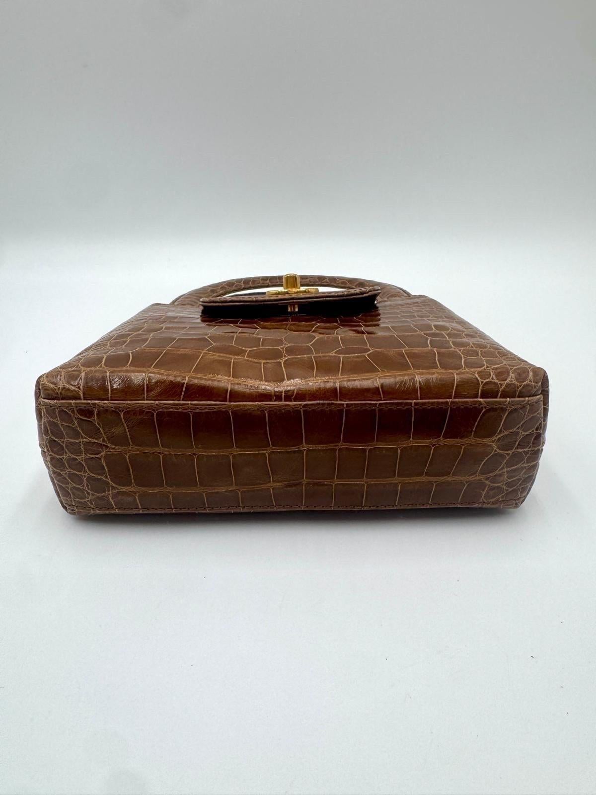 An incredibly rare vintage piece crafted from luxurious crocodile leather, this Chanel Mini Kelly is an exceptional collector’s item. The structured silhouette, top handle, and gold-tone CC turn-lock closure make it a timeless design seldom seen on