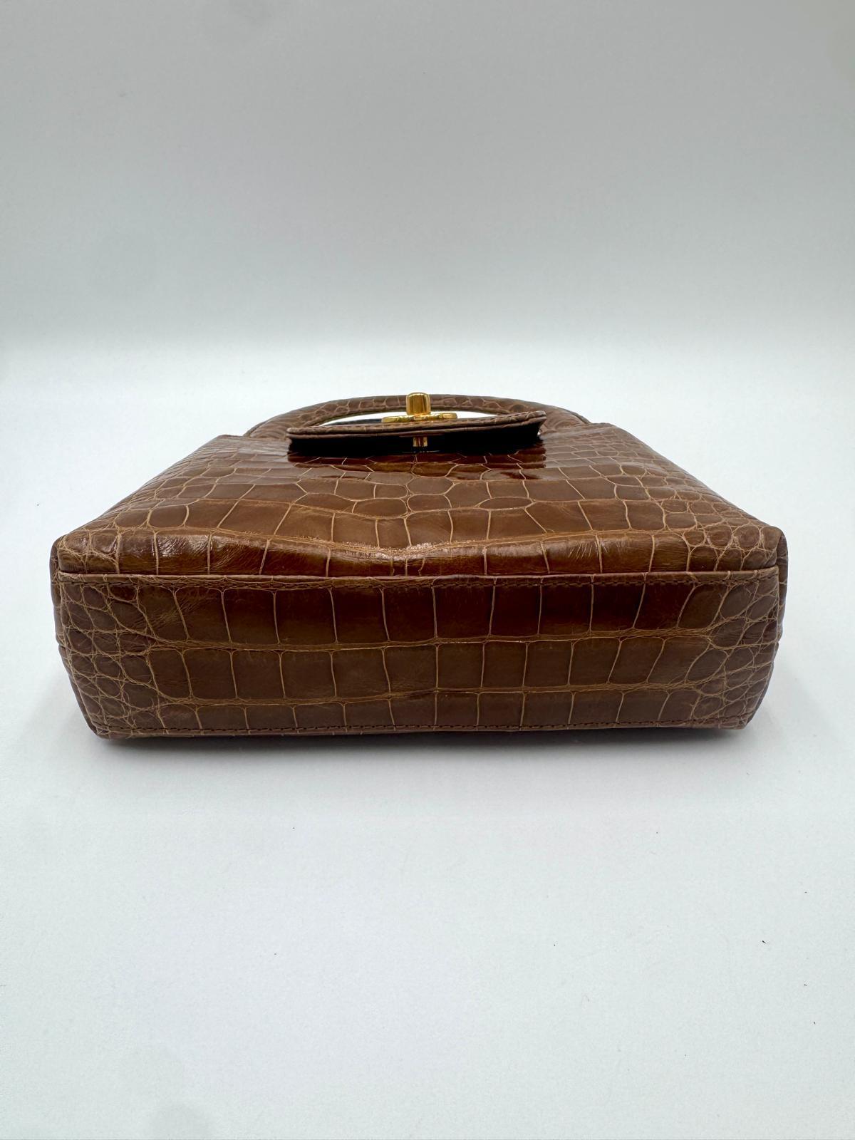 An incredibly rare vintage piece crafted from luxurious crocodile
leather, this Chanel Mini Kelly is an exceptional collector's item.
The structured silhouette, top handle, and gold-tone CC turn-lock
closure make it a timeless design seldom seen on
