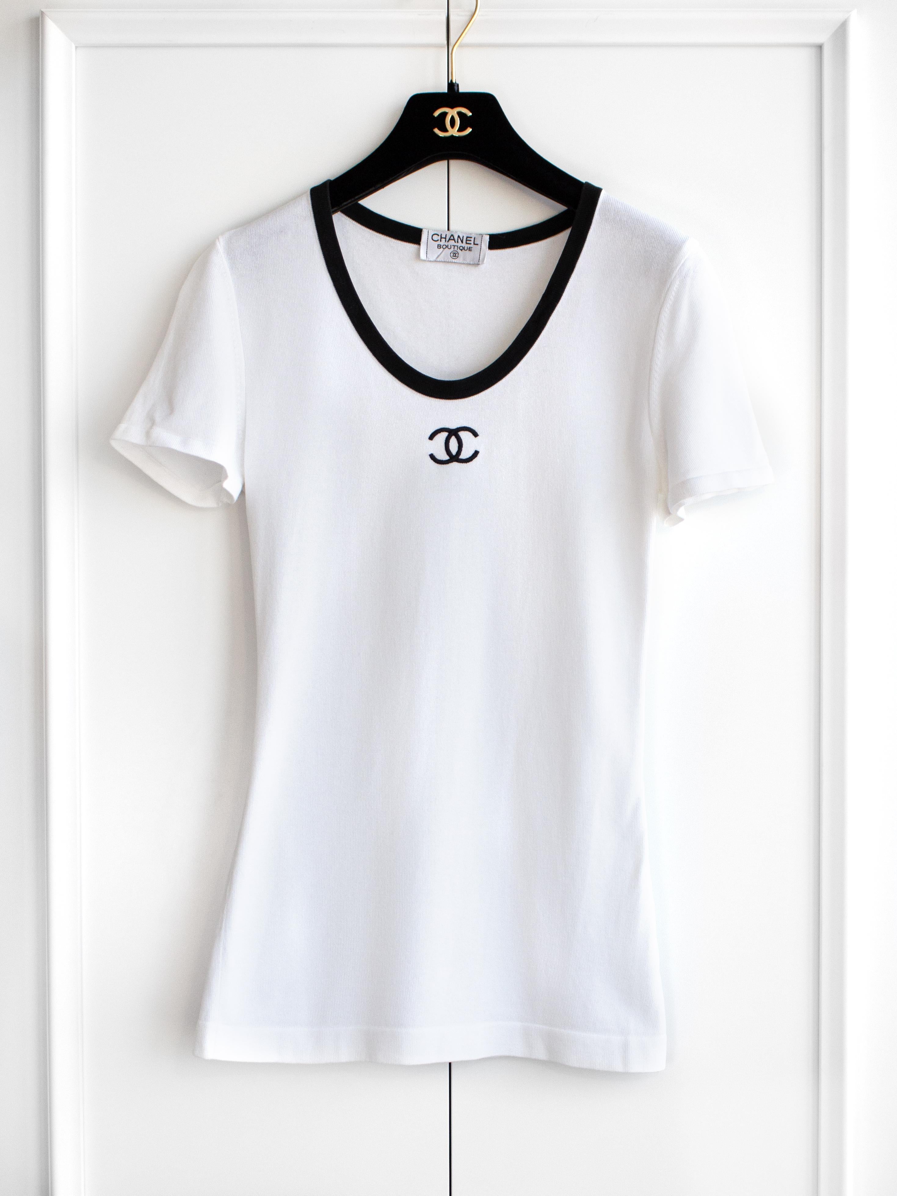 A classic scoop-neck white tee with a contrasting black trim and CC logo from Chanel Spring/Summer 1994 collection. Very good condition, no obvious flaws. Size FR34, stretchy cotton fabric. Composition label is missing. Measurements: bust 32