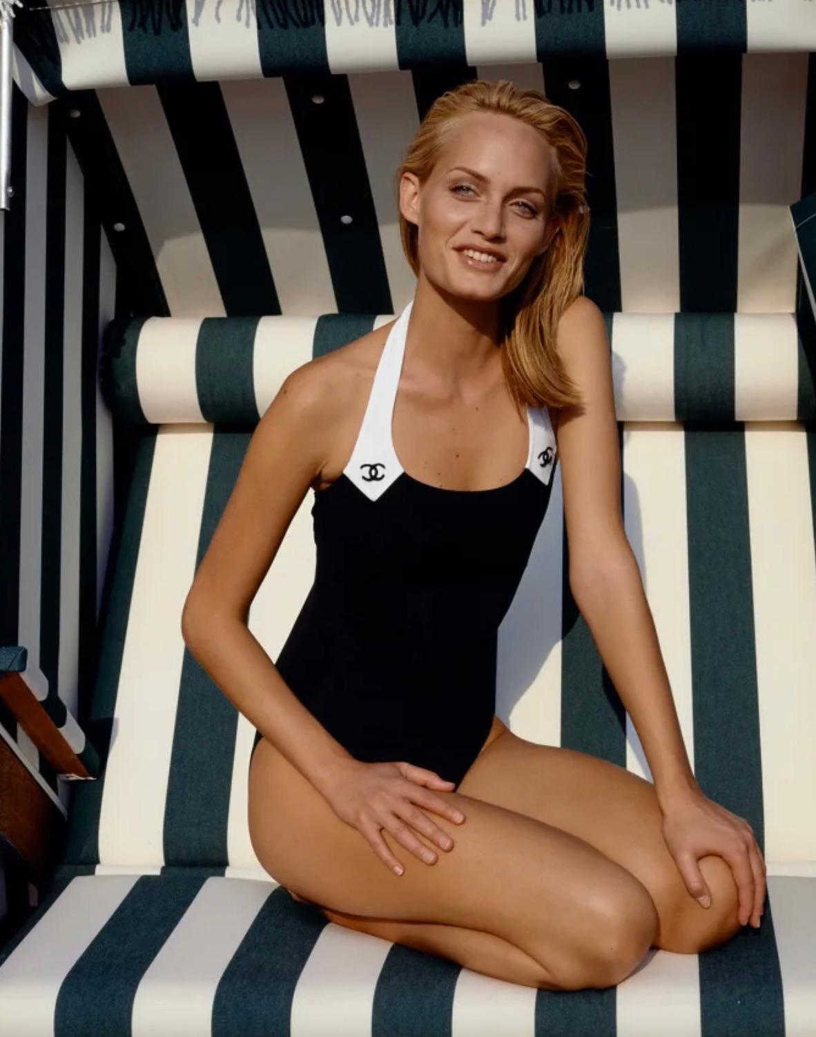 Introducing the stunning black and white logo swimsuit, a rare and coveted piece from the iconic 1996 cruise collection designed by the legendary Karl Lagerfeld for Chanel. Featuring embroidered logos and contrasting ivory white trims, this swimsuit