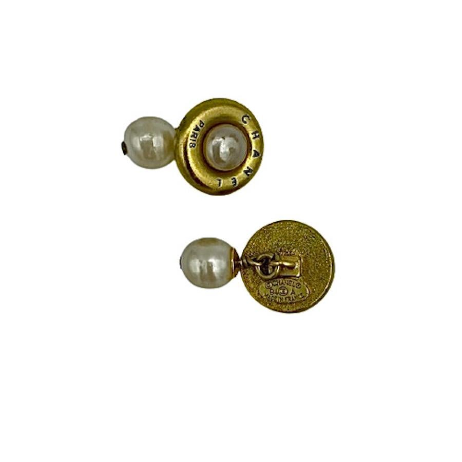 Vintage CHANEL cufflinks in gilt metal and pearl.
In very good condition.
Made in France. Unisex jewelry.
Dimensions: 2 x 2 cm
Stamp: yes
Fall 1994 collection.

Will be delivered in its original box