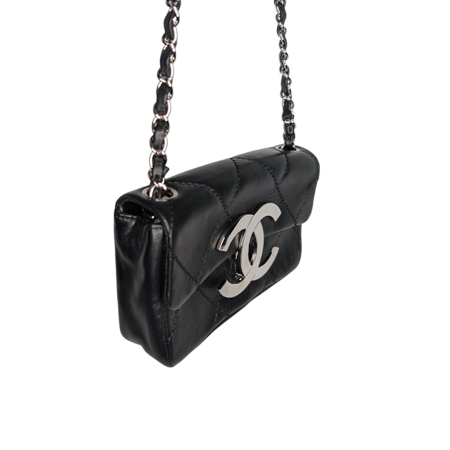 This stylish shoulder bag is crafted of luxurious diamond stitched lambskin leather in black. The bag features a silver chain link threaded with black leather and a large polished CC silver-tone hinge clasp at the front flap. This opens to a channel