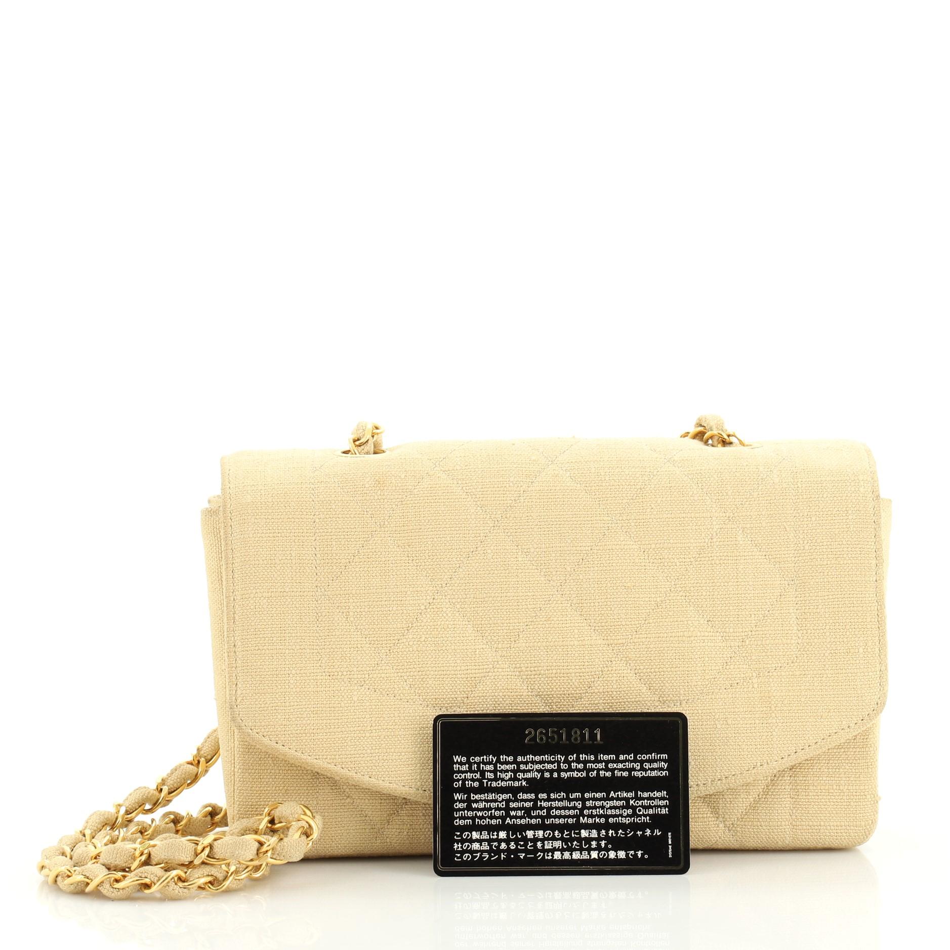 This Chanel Vintage Diana Flap Bag Quilted Canvas Small, crafted in neutral canvas, features woven in leather chain link strap and gold-tone hardware. Its CC turn-lock closure opens to a neutral leather interior with zip and slip pockets. Hologram
