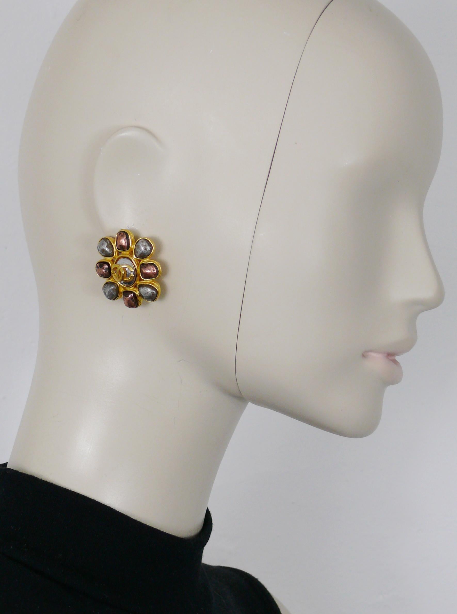 CHANEL by KARL LAGERFELD vintage gold toned clip-on earrings featuring a stylized flower embellished with distressed copper and silver toned metal cabochons. CC logo at center.

Fall 1997 Collection.

Embossed CHANEL 97A Made in France.

Indicative