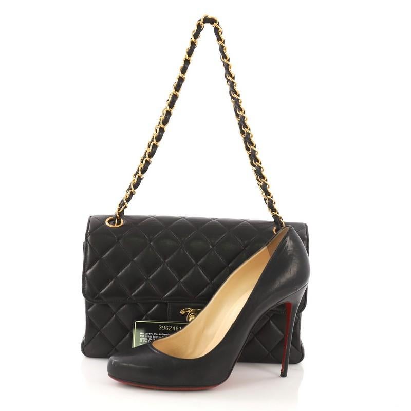 This Chanel Vintage Double Sided Flap Bag Quilted Lambskin Small, crafted in black quilted lambskin leather, features woven-in leather chain strap, flap on each side, and gold-tone hardware. Its CC turn-lock closure opens to a black leather interior