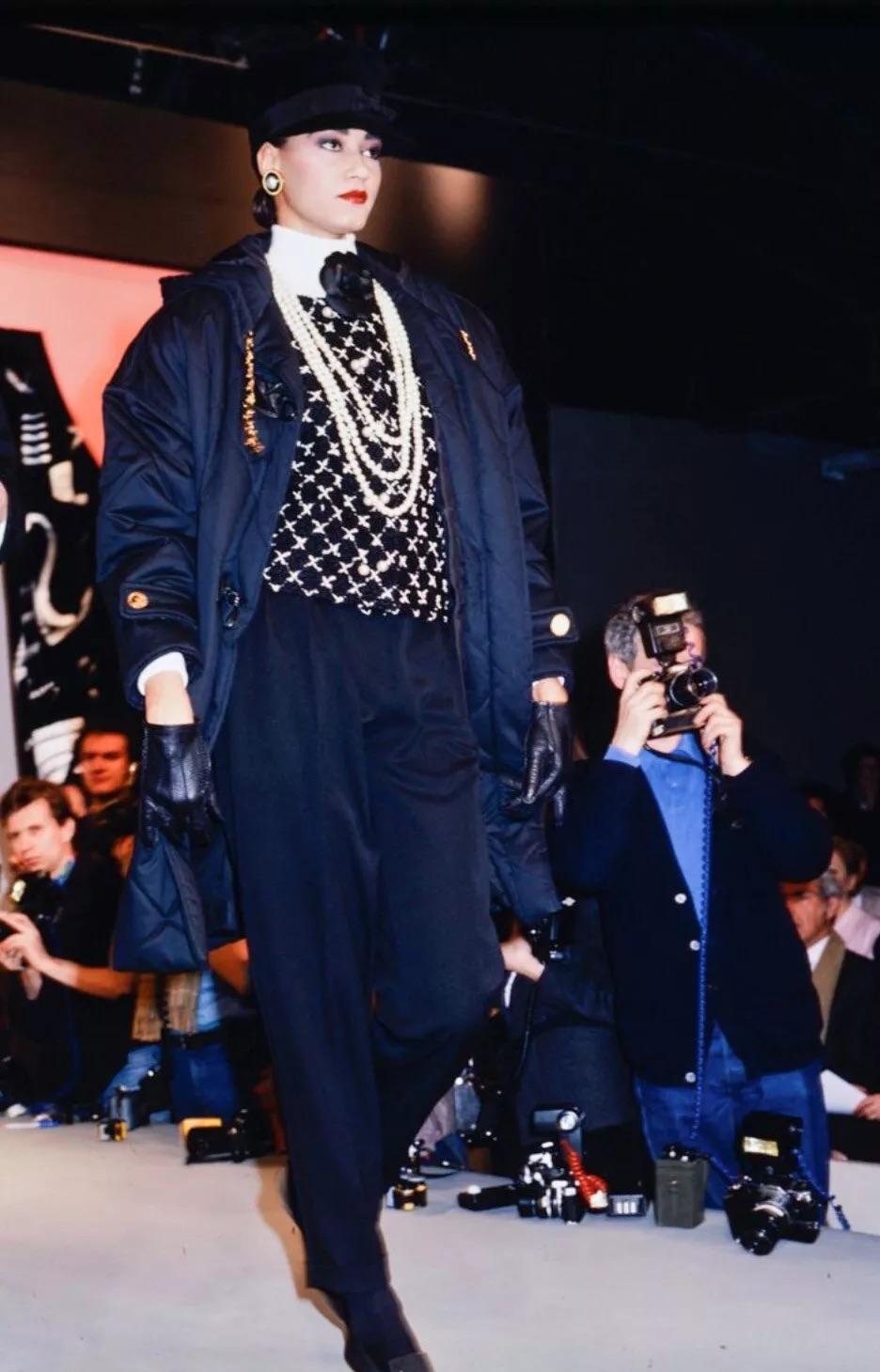 This is a vintage Chanel suit from the Fall/Winter 1987 collection, designed by Karl Lagerfeld. It features a black and white tweed pattern with delicate 