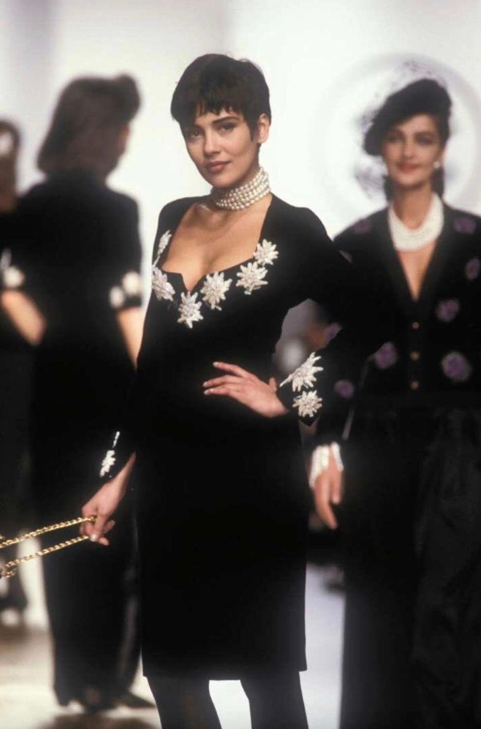This rare Chanel dress is from the Fall/Winter 1988 ready-to-wear collection designed by Karl Lagerfeld. Crafted from rich black velvet, it features a flattering mini-length silhouette with long sleeves and a subtle notched neckline. The highlight