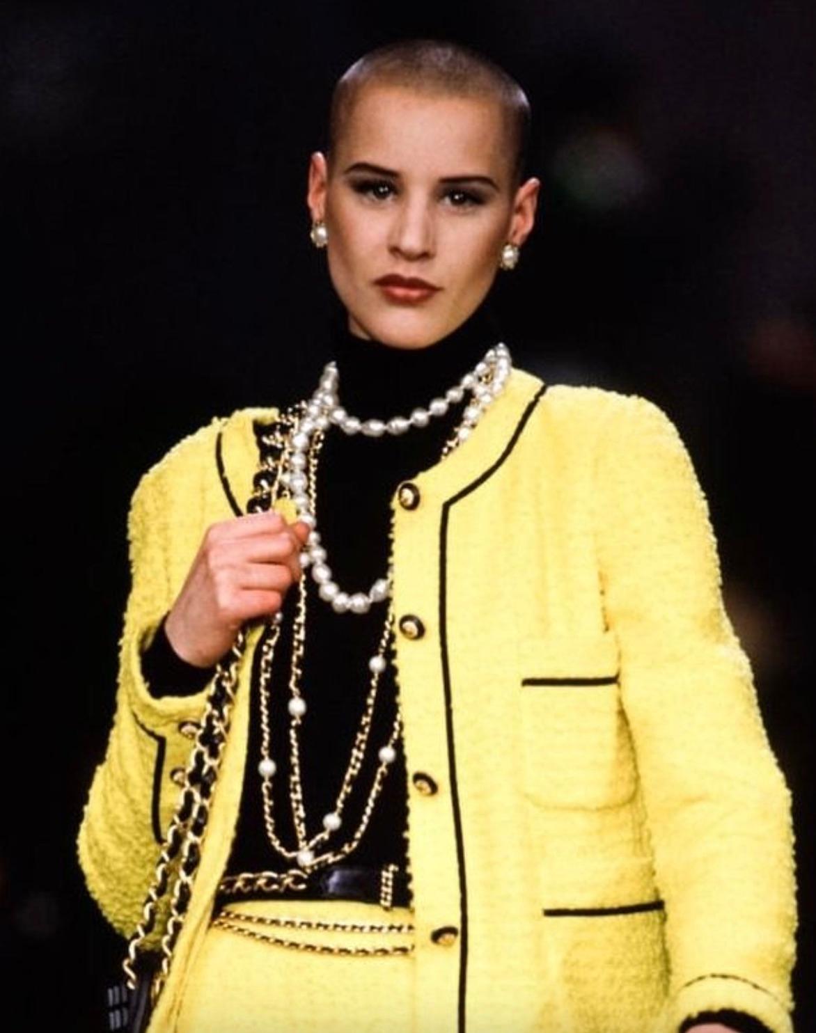 This is a rare and hard-to-find vintage Chanel suit from the Fall 1993 collection, an iconic example of the brand's classic elegance. The set features a vibrant chartreuse yellow tweed fabric beautifully contrasted with bold black velvet trims. The