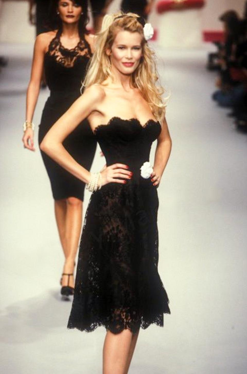 This vintage Chanel dress from the Fall/Winter 1995 collection is an iconic piece famously worn by Claudia Schiffer on the runway. Designed by Karl Lagerfeld, the dress is crafted from intricate black floral lace with a romantic, strapless