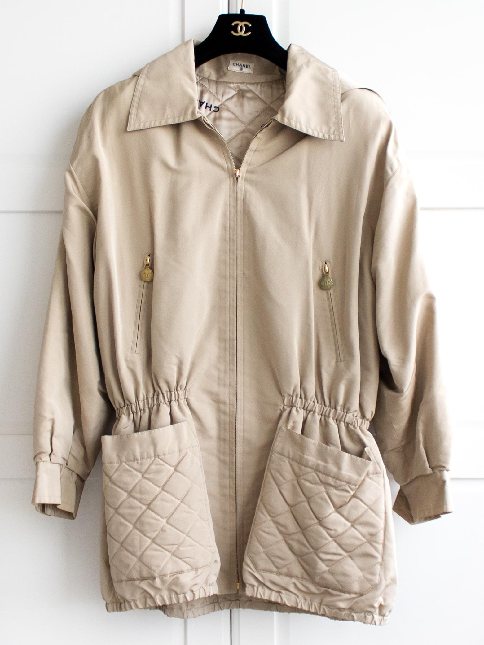 Rare trench jacket from Chanel Fall 1994 collection. This stunning oversized trench jacket with quilted lining and contrasting CHANEL letters throughout is classic yet edgy. Good condition for its age with some flaws: slight wear to fabric, light