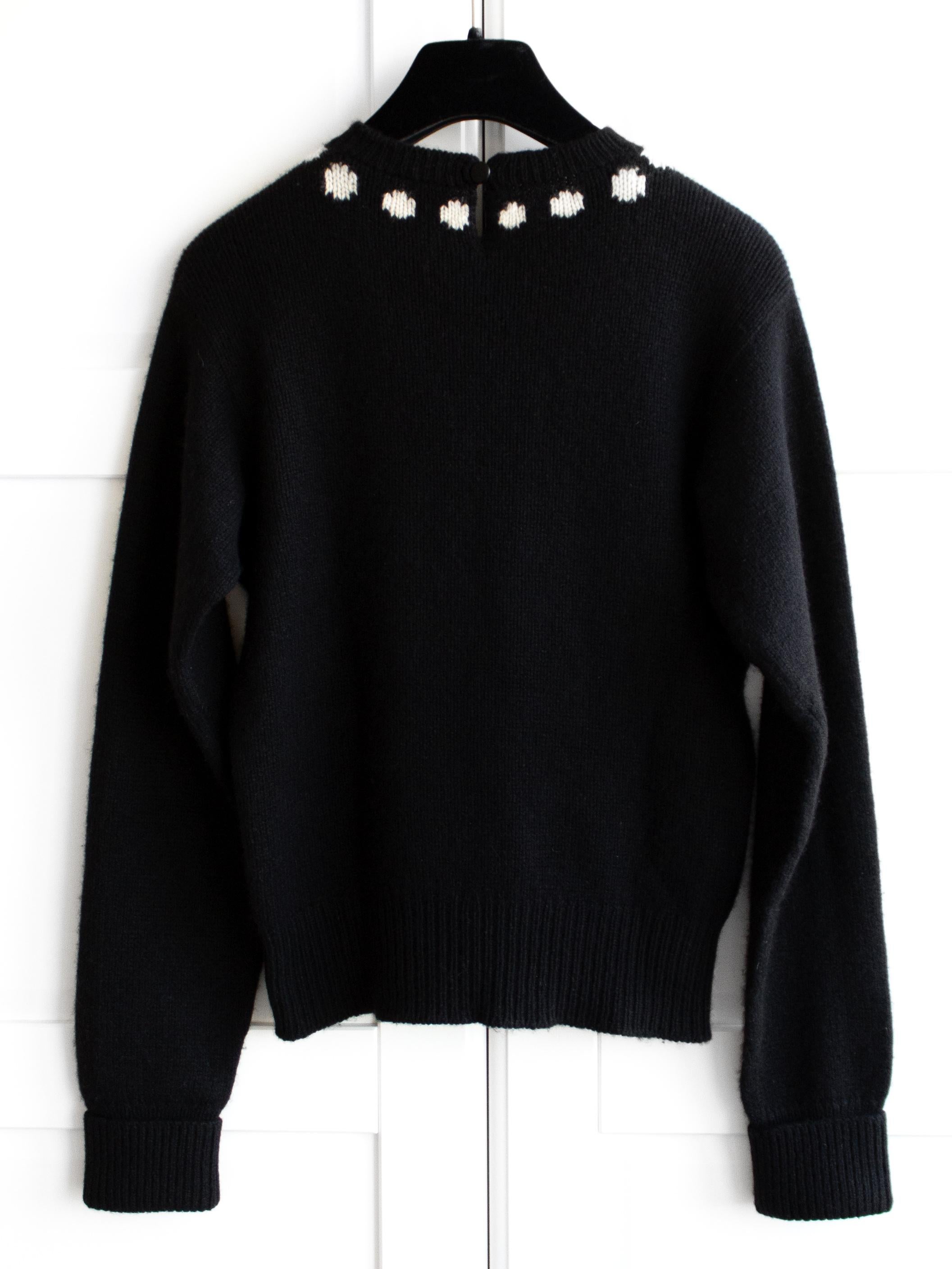 Rare black sweater from Chanel Fall 1995 collection. Knitted from soft black cashmere, this Chanel jumper is adorned with an intarsia knit resembling a white pearl necklace with a multicolor gripoix pendant. Very good condition for its age, no