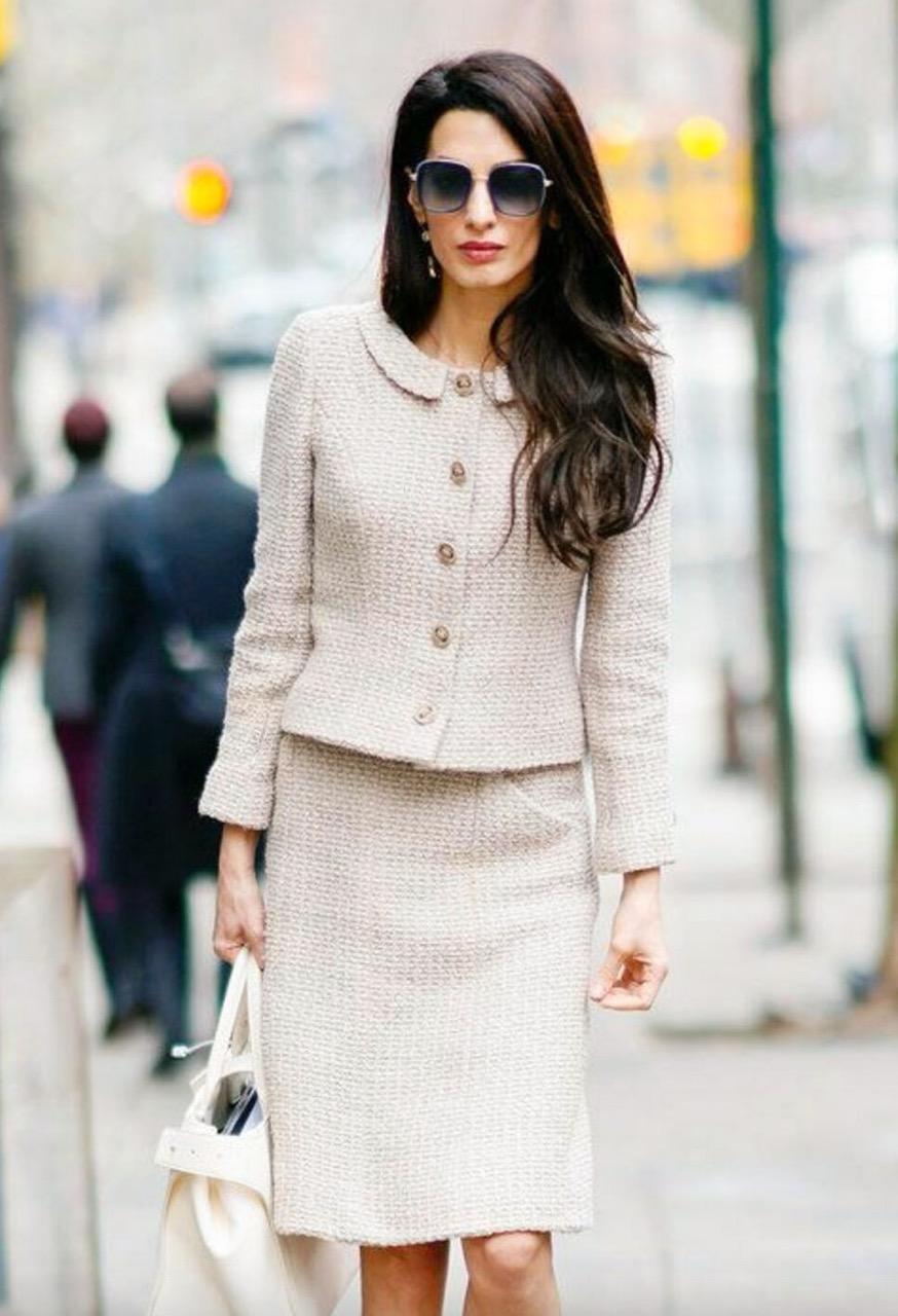 A classic beige tweed jacket and skirt suit from Chanel Fall 2002 collection. As seen on Amal Clooney. This elegant suit is made of beige tweed with slightly shimmery green threads. The jacket features a round collar and leather buttons. Matching