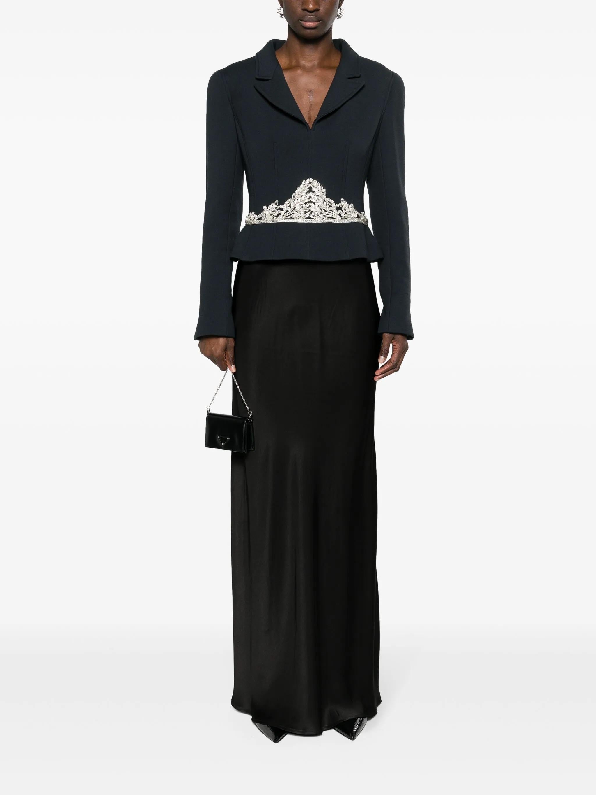 This rare Chanel jacket is from the Fall/Winter 2002 collection, designed by Karl Lagerfeld. Crafted in a deep navy blue, the jacket is tailored with a structured silhouette and features a sharp notched lapel collar. Its standout detail is the