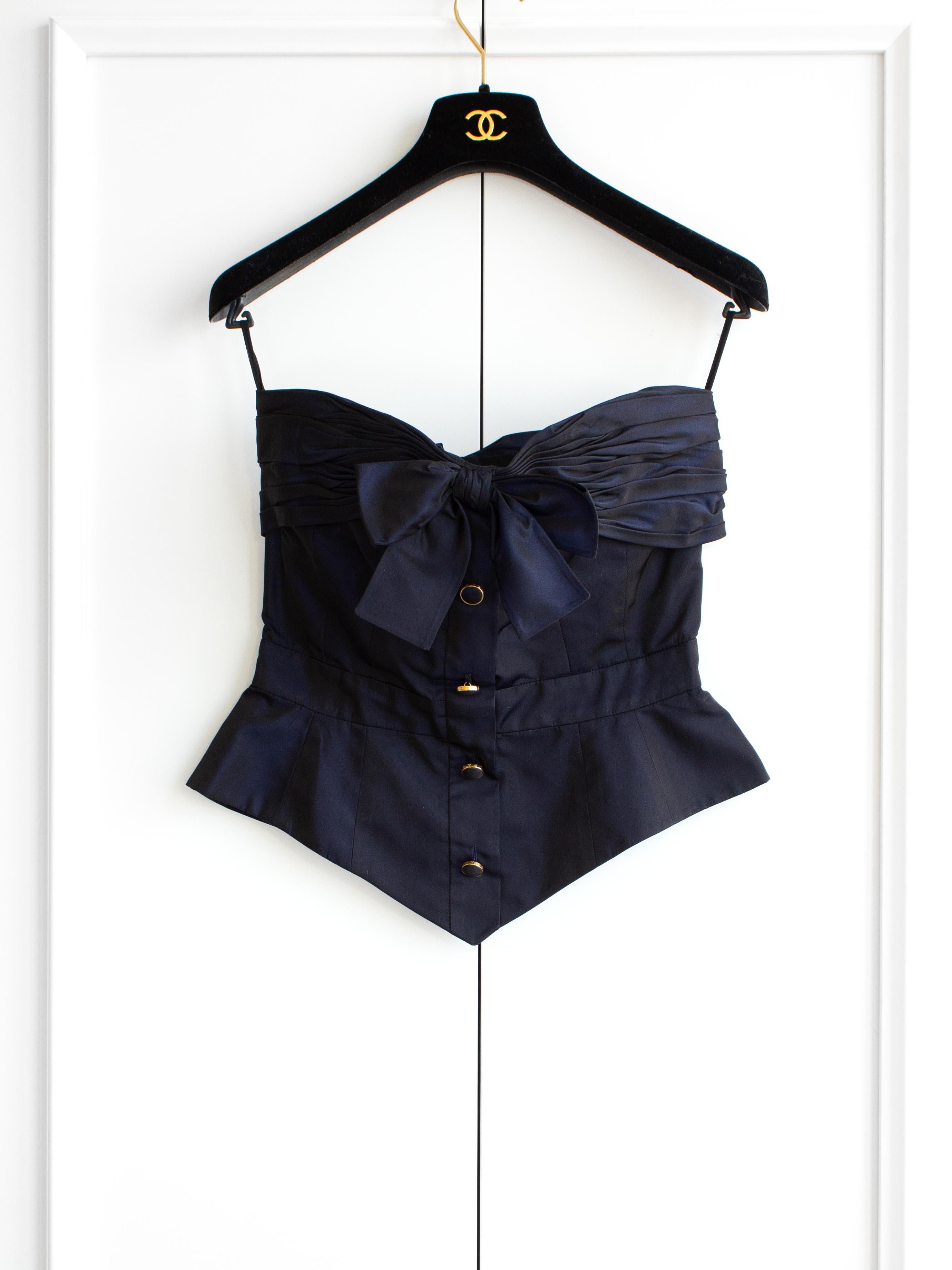 Indulge in timeless elegance with this enchanting midnight blue iridescent silk taffeta bustier top from Chanel's Fall/Winter 1991 collection. Crafted to perfection, the fitted silhouette features a captivating bow accent and four delicate buttons