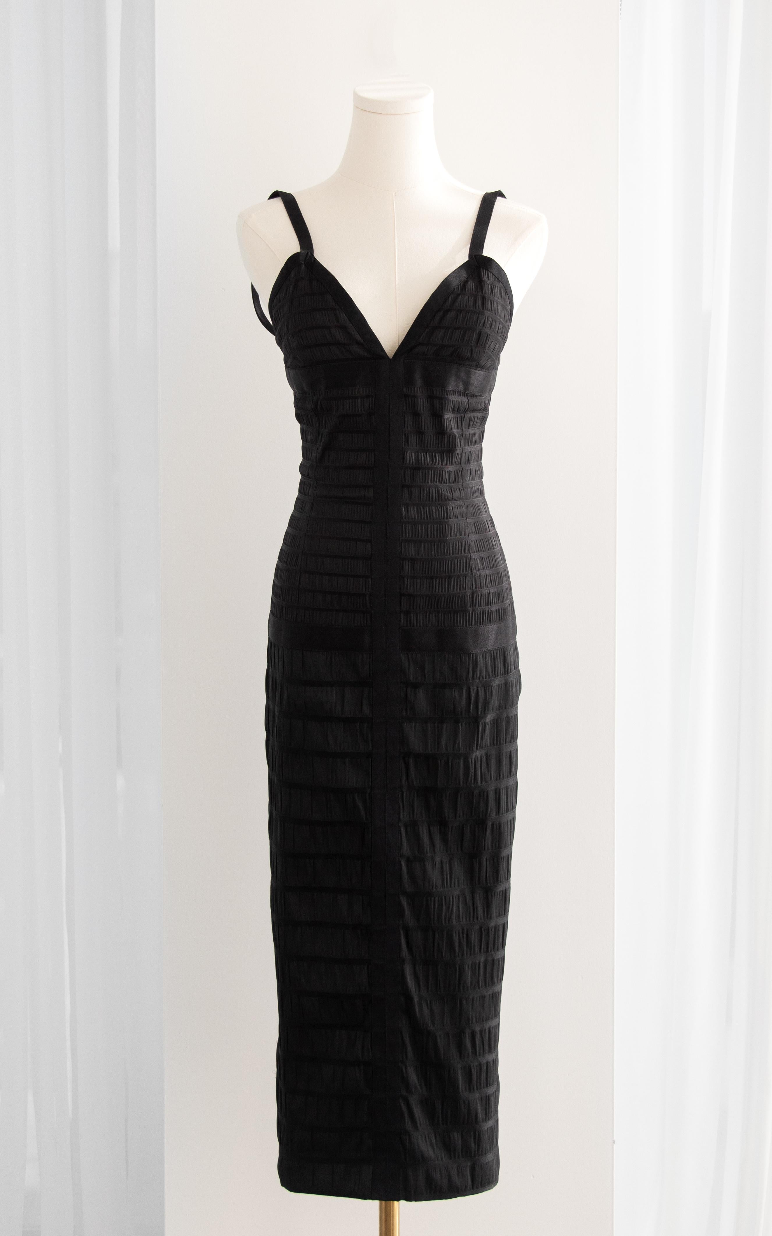 The Chanel Vintage Fall 1992 black silk bodycon midi dress is a piece of fashion history, famously seen on supermodel Eva Herzigová as she graced the runway. This iconic design captures the essence of Chanel's timeless elegance with its luxurious