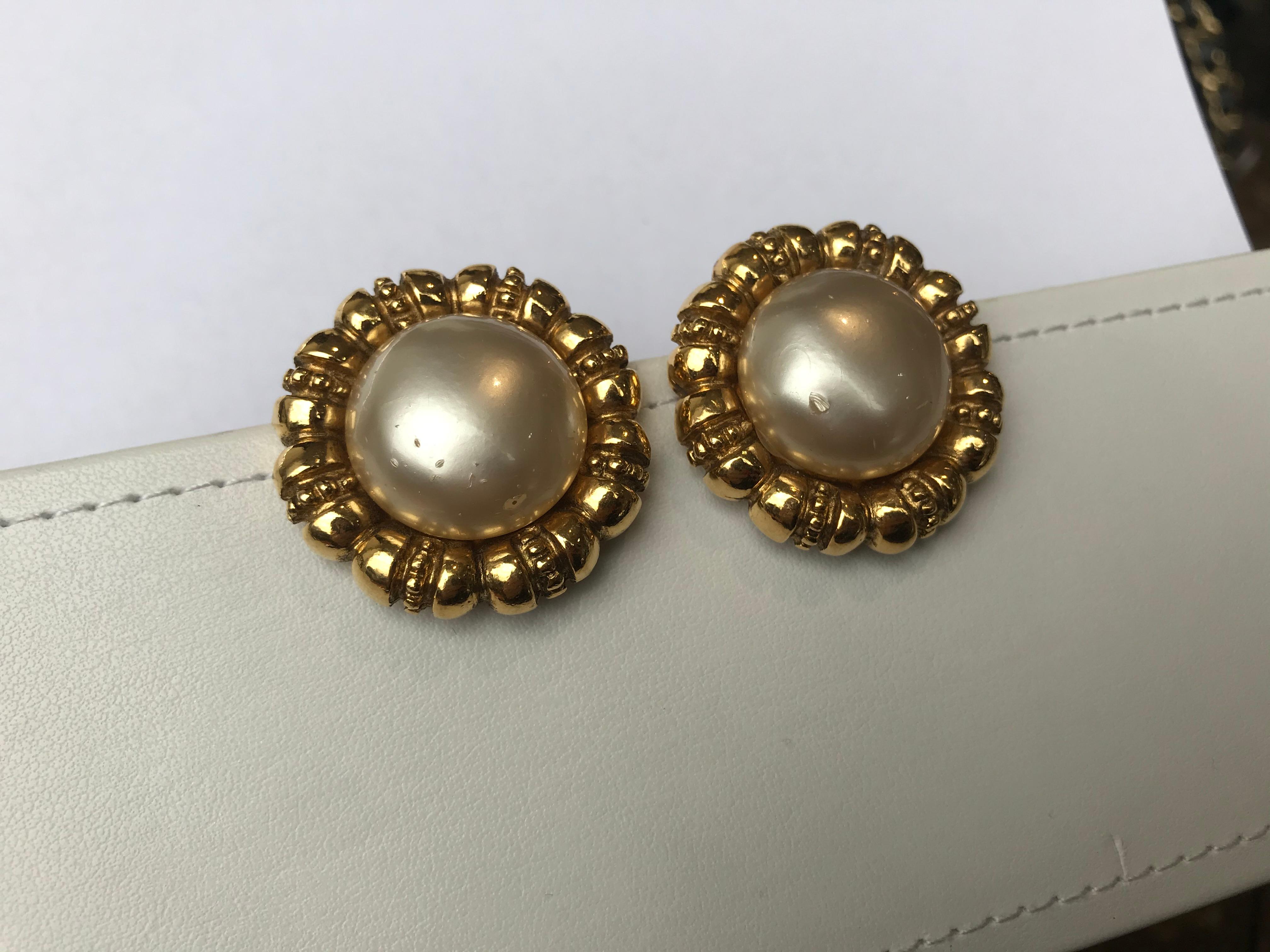 Gold-tone metal. Faux pearl at center. Clip-on closures.