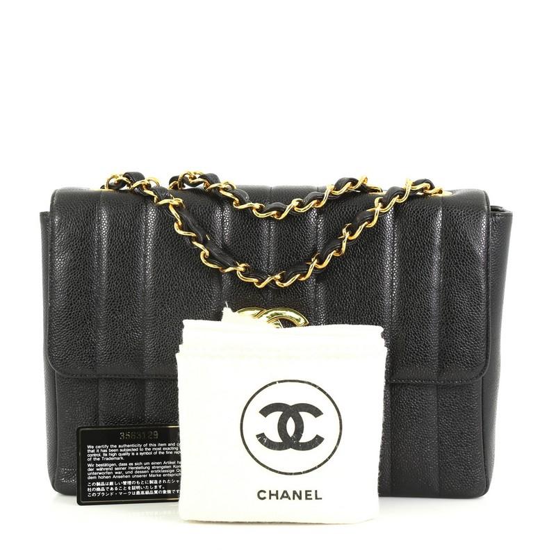 This Chanel Vintage Flap Bag Vertical Quilt Caviar Jumbo, crafted in black vertical quilted caviar, features woven-in leather chain link straps and gold-tone hardware. Its CC turn-lock closure opens to a black leather interior with zip and slip