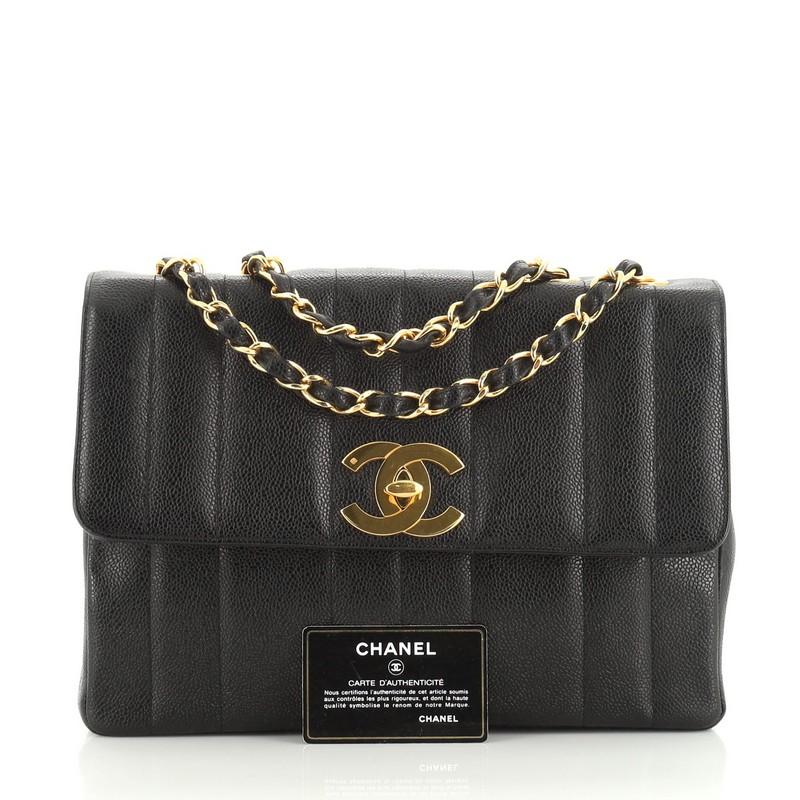 This Chanel Vintage Flap Bag Vertical Quilt Caviar Jumbo, crafted in black vertical quilted caviar, features woven-in leather chain link straps and gold-tone hardware. Its CC turn-lock closure opens to a black leather interior with zip and slip