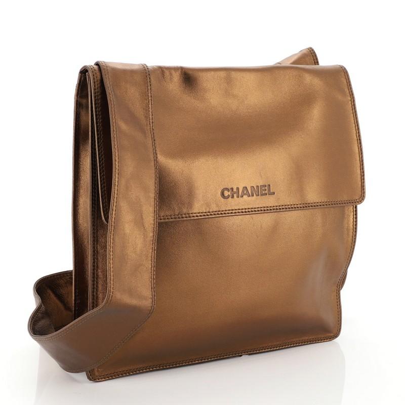 This Chanel Vintage Flat Crossbody Bag Leather Medium, crafted in metallic gold leather, features a flat shoulder strap and gold-tone hardware. Its magnetic closure opens to a brown nylon interior with zip pocket. Hologram sticker reads: 5792889