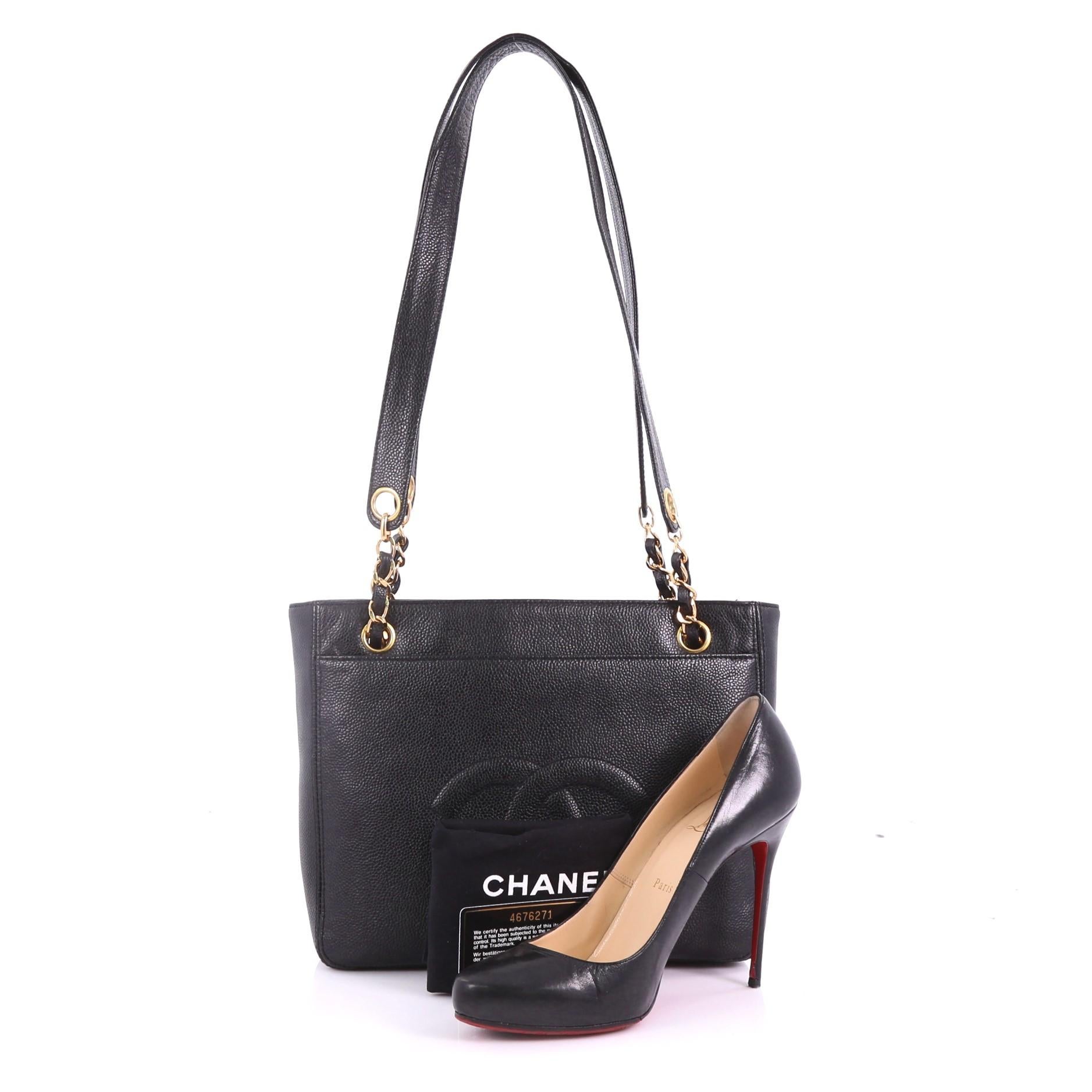 This Chanel Vintage Front Pocket Tote Caviar Small, crafted from black caviar leather, features woven-in chain and leather straps, front flap with CC turn-lock closure and gold-tone hardware. It opens to a black fabric interior with zip pocket.