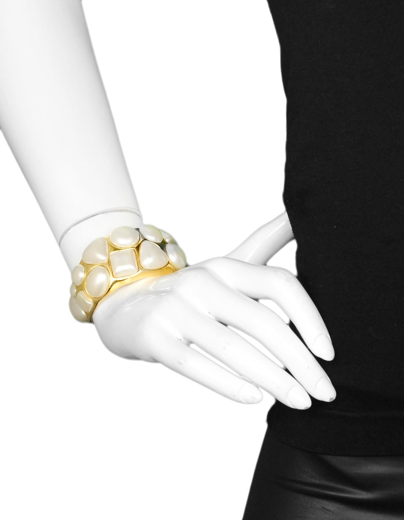 Chanel Vintage '87 Goldtone & Geometrische Faux Pearl Manschettenarmband

Hergestellt in: Frankreich
Jahr der Herstellung: 1987
Stempel: 2 CC 6
Verschluss: Keine
Farbe: Goldtone und Elfenbein
Materialien: Metall und Kunstperle
Allgemeiner Zustand: