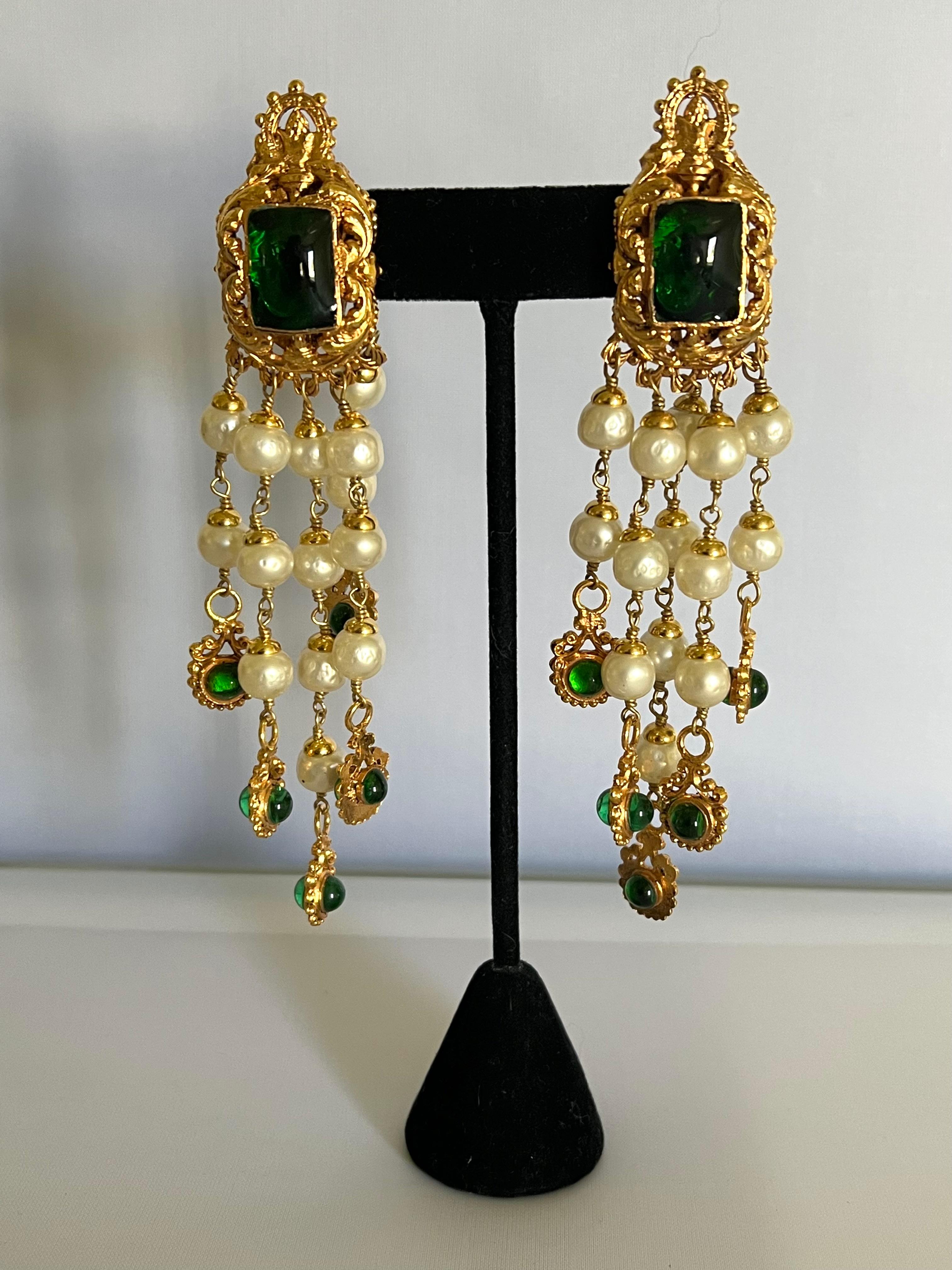 Rares boucles d'oreilles à clips vintage Coco Chanel « doré métallique », de couleur dorée, présentant un design baroque orné de verre vert émeraude «pate de verre » et de perles en faux verre. Les boucles d'oreilles sont signées et figurent sur la