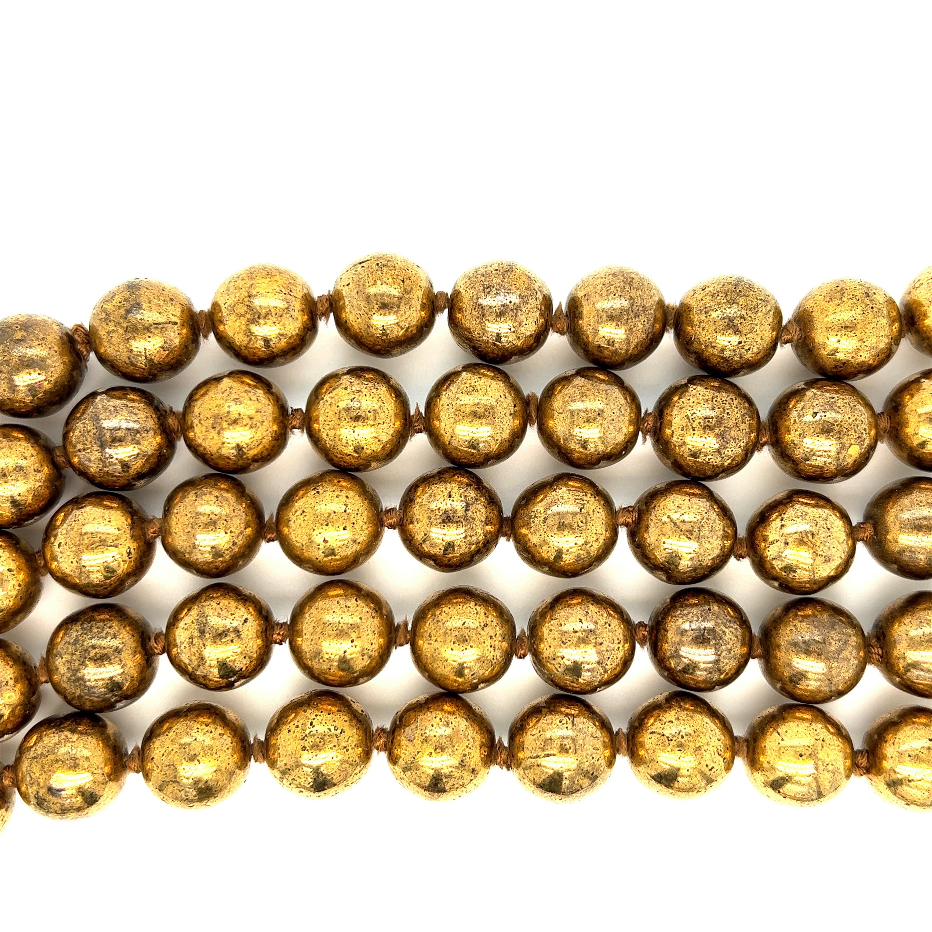 Chanel vintage gilt-metal bead bracelet, made in France

Five-strand gilt-metal beads (13 mm), forming a wide bracelet; marked Chanel, 23, made in France

Size: width 2.5 inches, length 7 inches
Total weight: 200.9 grams