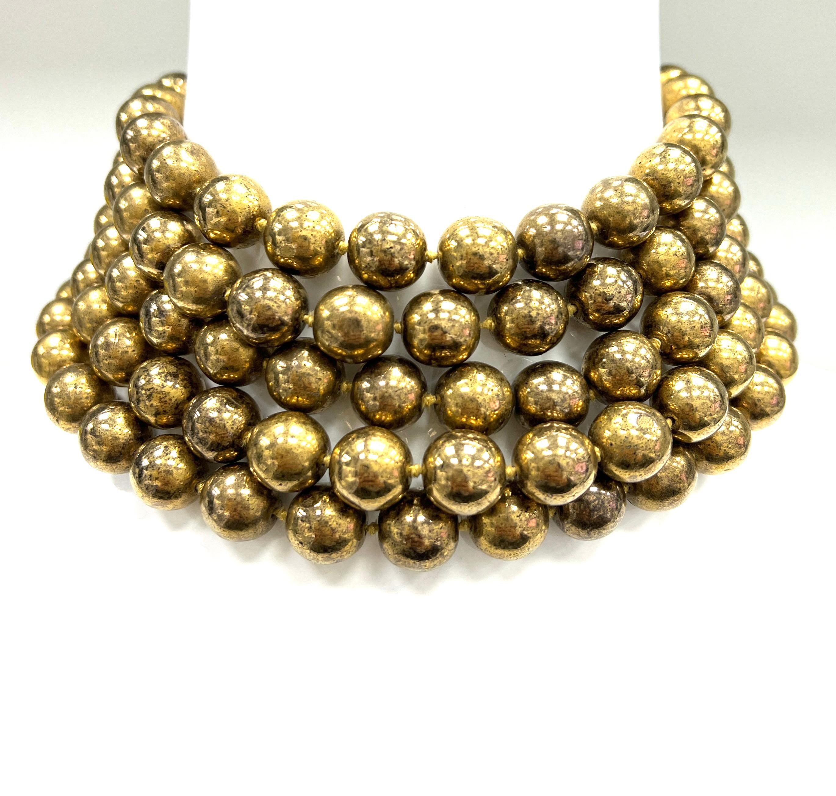 Chanel vintage gilt-metal bead necklace, made in France

Five-strand gilt-metal beads (13 mm), forming a wide choker; marked Chanel, 23, made in France

Size: width 2.5 inches, length 14 inches
Total weight: 390.2 grams